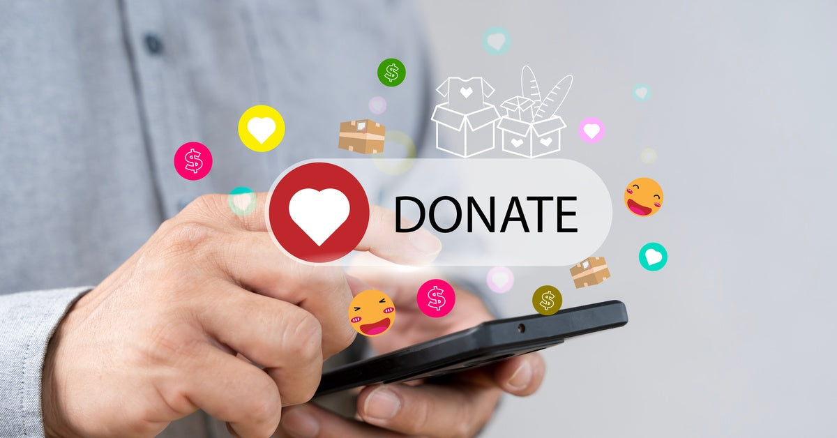 A hand holds a phone with social media graphics above the screen. One graphic says "Donate" with a heart emoji.
