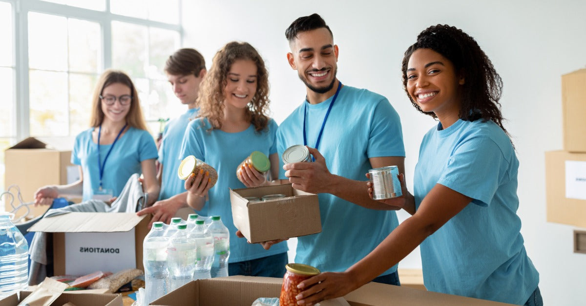 Volunteers sort food and bottled water into donation boxes while preparing supplies for community distribution.